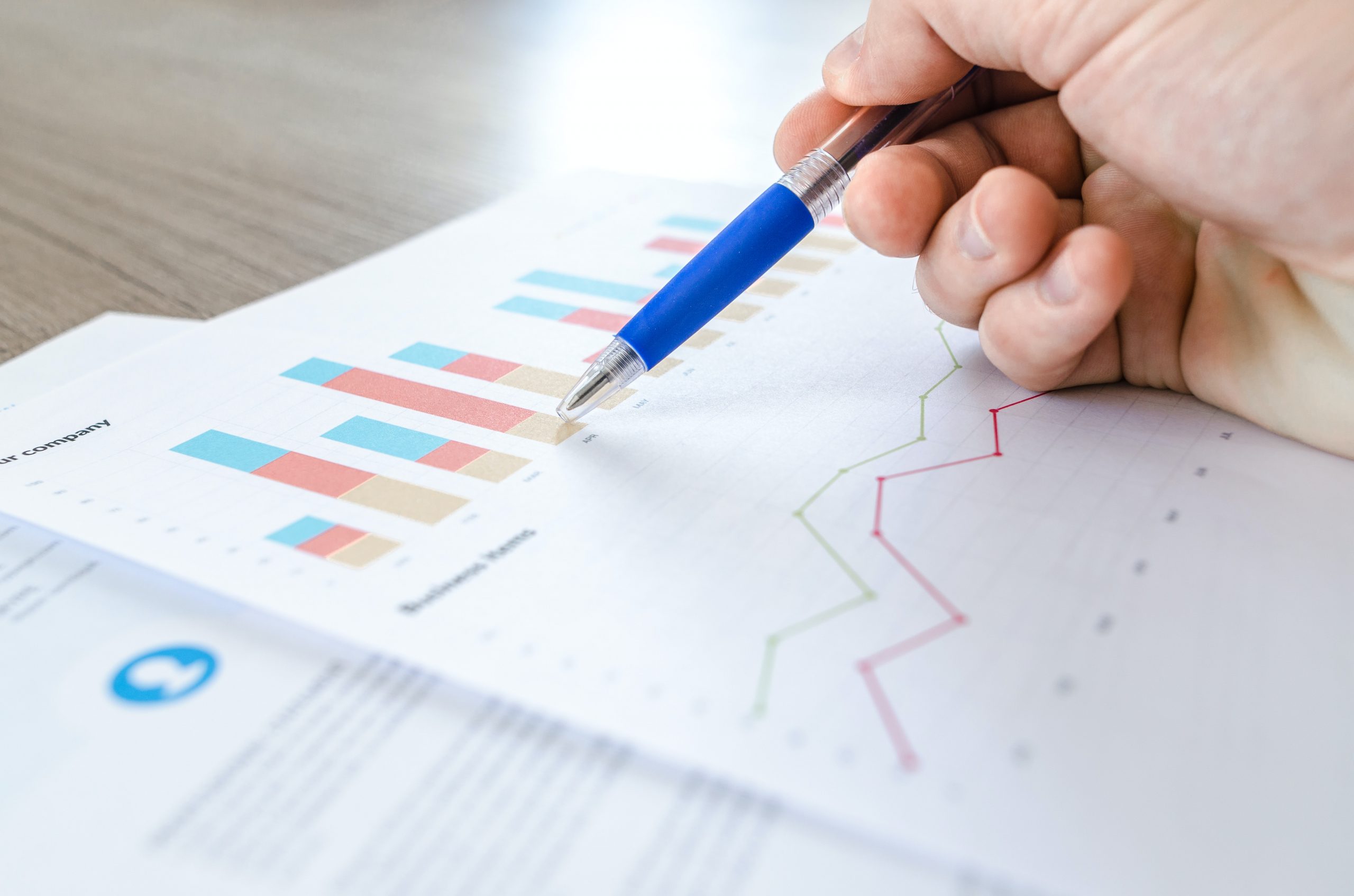 pen pointing at graphs on a sheet of paper